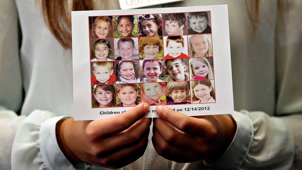 Kyra Murray holds a photo showing victims of the shooting at Sandy Hook Elementary School during a press conference at the U.S. Capitol calling for gun reform legislation, Sept. 18, 2013, in Washington, D.C.