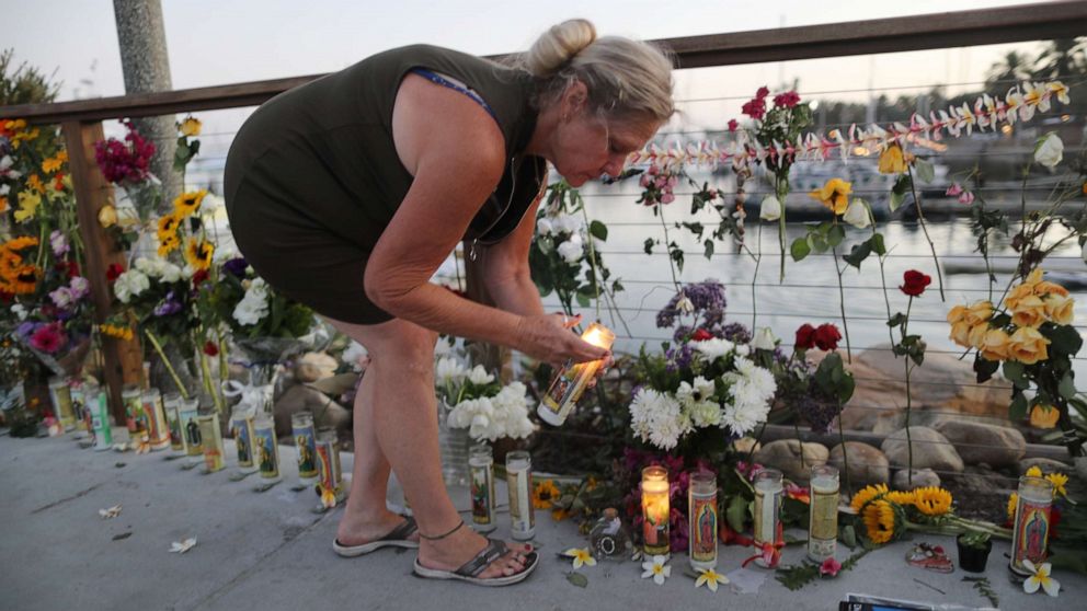 PHOTO: A woman lights a candle in Santa Barbara Harbor at a makeshift memorial for victims of the Conception boat fire on Sept. 3, 2019 in Santa Barbara, Calif.