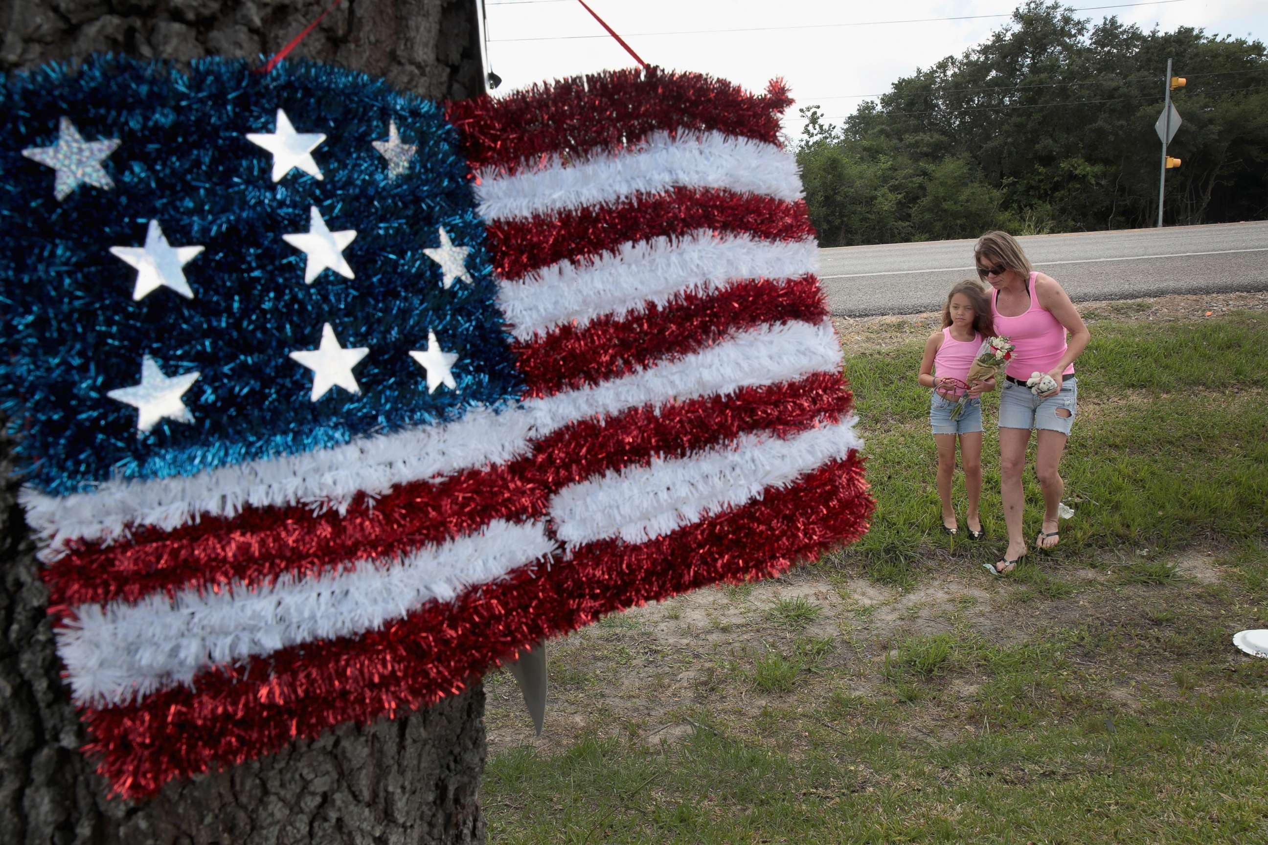 PHOTO: Carissa Potts and her 7-year-old daughter Kaylee bring flowers to a small memorial outside of  Santa Fe High School, May 19, 2018 in Santa Fe, Texas. 