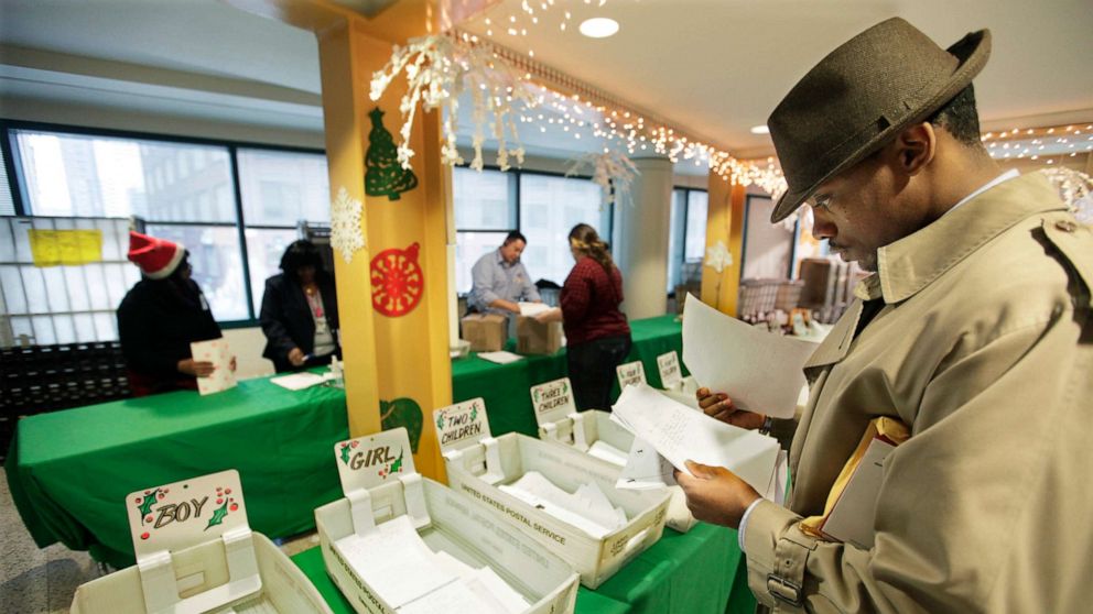 PHOTO: In this Dec. 21, 2011, file photo, Mel Roberson reads through letters from children as he participates in the U.S. Postal Service's Operation Santa program at the main post office in Chicago.