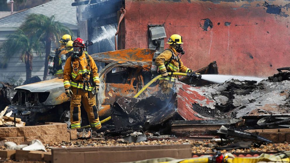 A small twin engine plane has crashed in Santee, California, near San Diego, fully engulfing at least one home in flames.