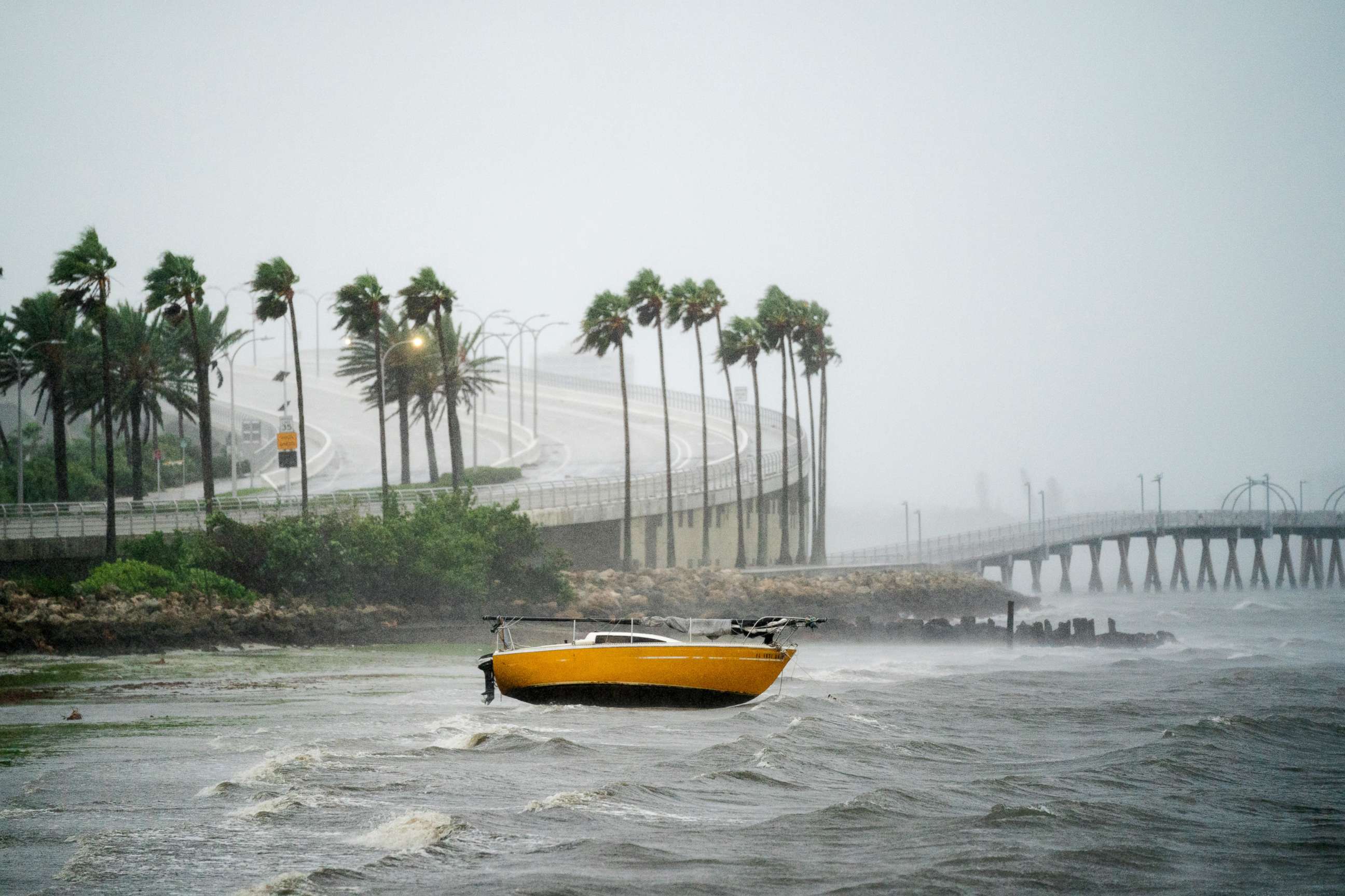 PHOTO: A sail boat is washed into shallow waters at Sarasota Bay as Hurricane Ian approaches on Sept. 28, 2022, in Sarasota, Fla.
