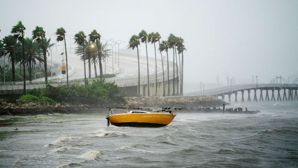 PHOTO: A sail boat is washed into shallow waters at Sarasota Bay as Hurricane Ian approaches on Sept. 28, 2022, in Sarasota, Fla.