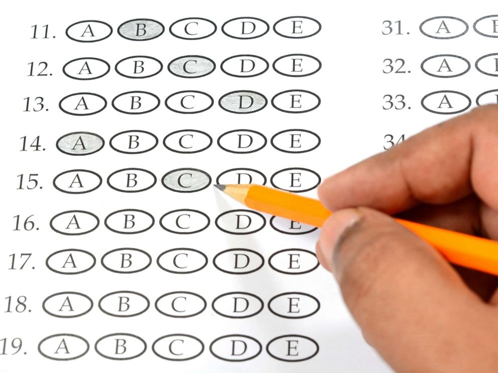 PHOTO: A student appears to be filling out a multiple choice exam paper with a pencil.
