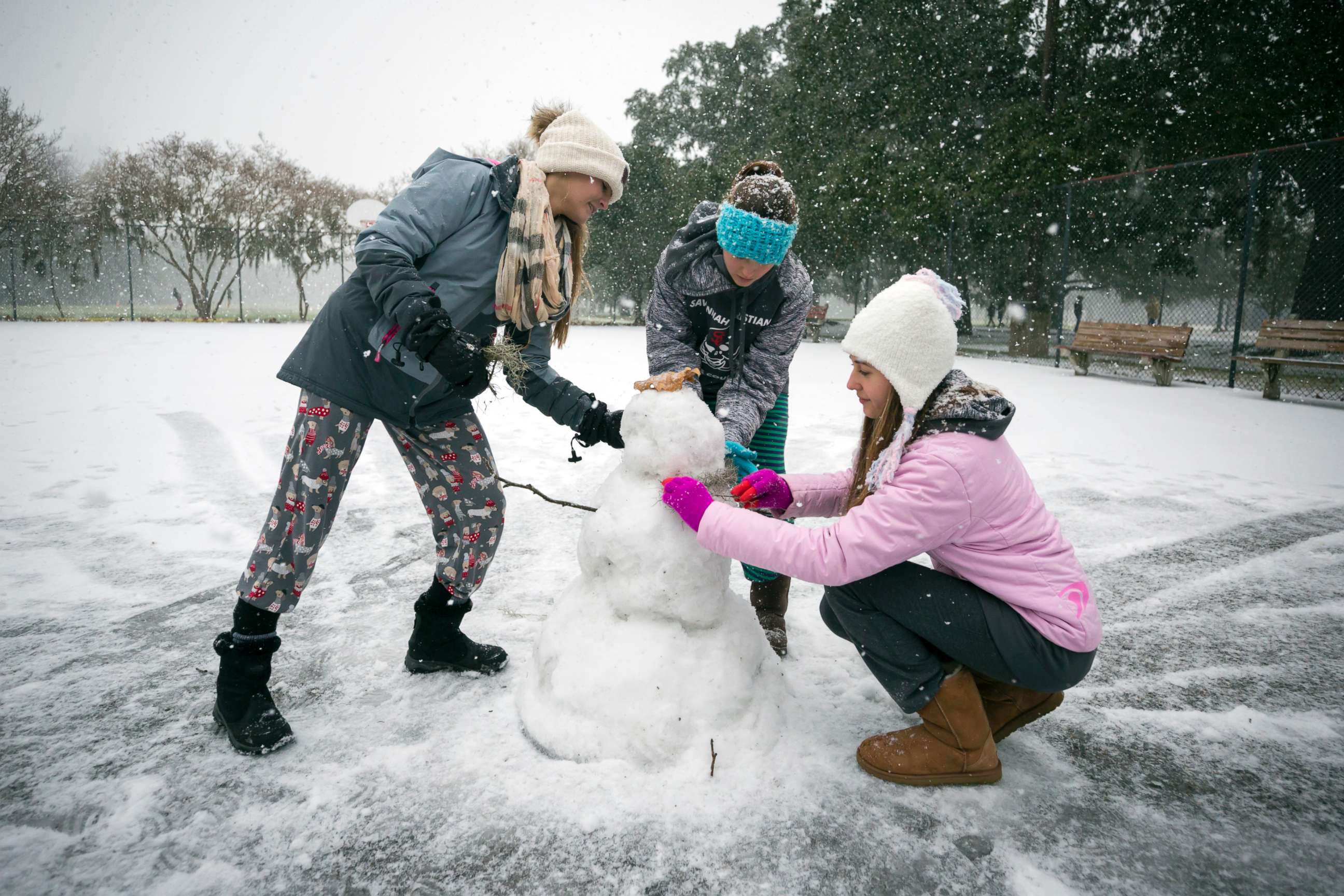 PHOTO: Children from the Hoffman and Lynns families build a snowman on the public basketball courts in Forsyth Park, Jan. 3, 2018, in Savannah, Ga.