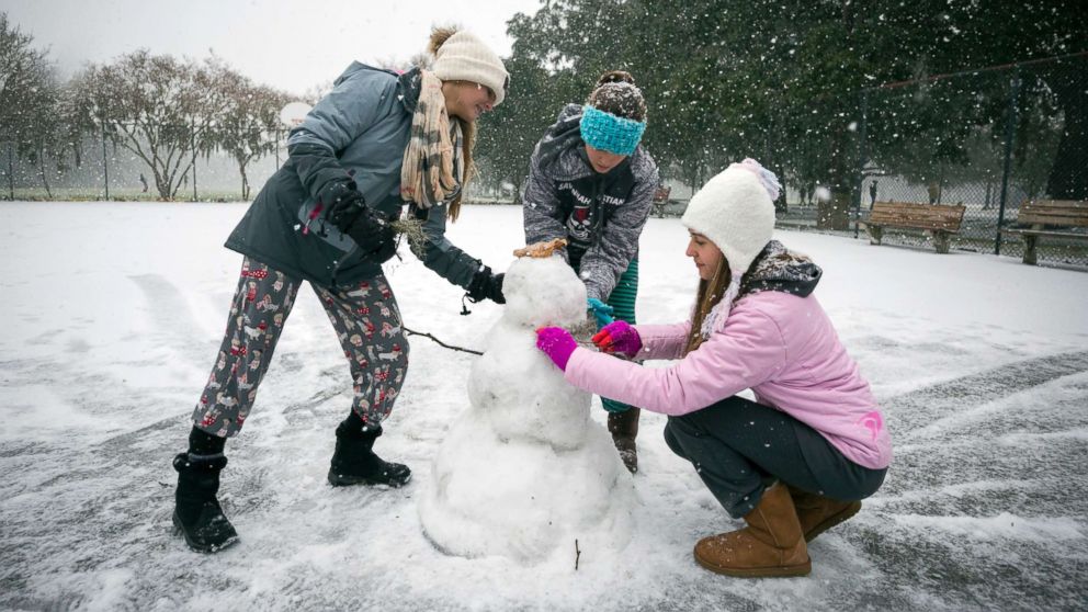 PHOTO: Children from the Hoffman and Lynns families build a snowman on the public basketball courts in Forsyth Park, Jan. 3, 2018, in Savannah, Ga.