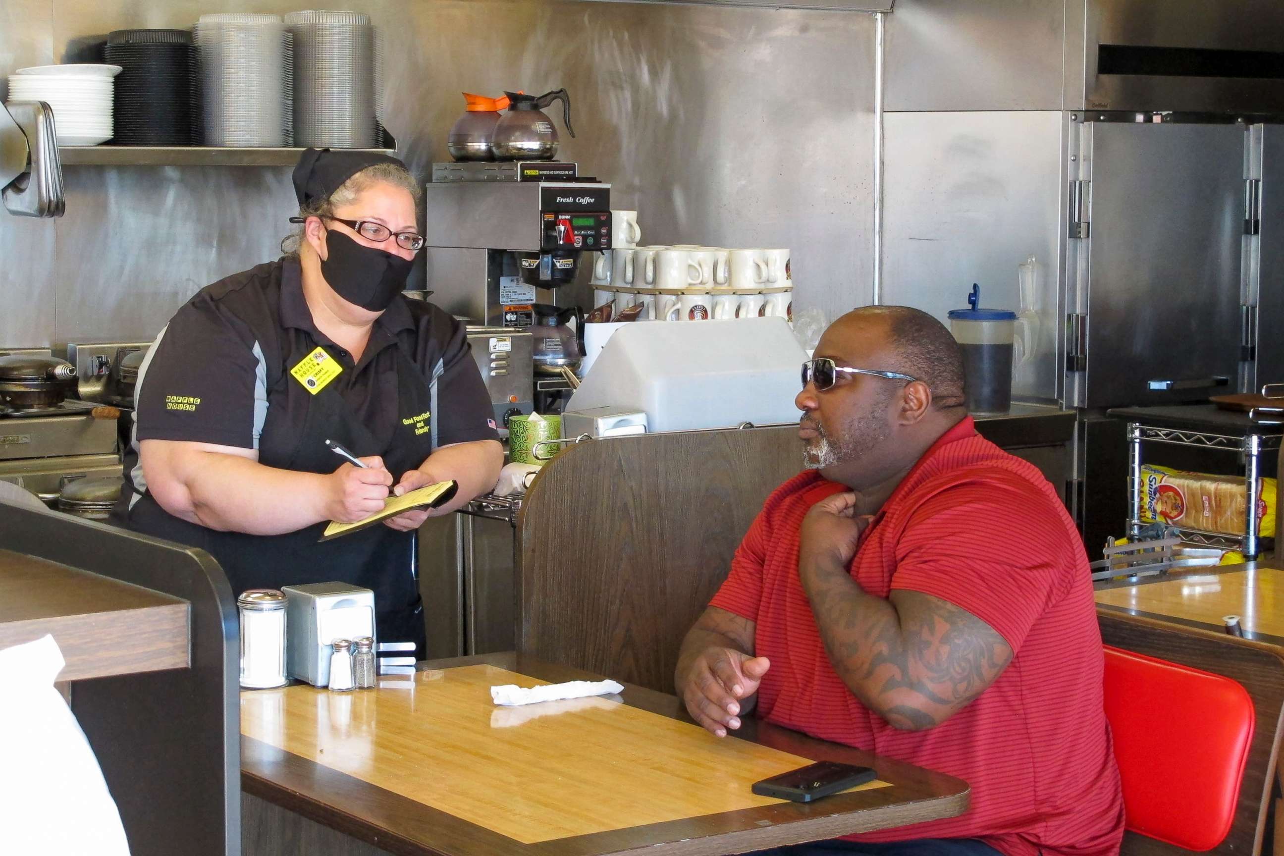 PHOTO: In this April, 27, 2020, file photo, a man orders food at a Waffle House restaurant in Savannah, Ga.