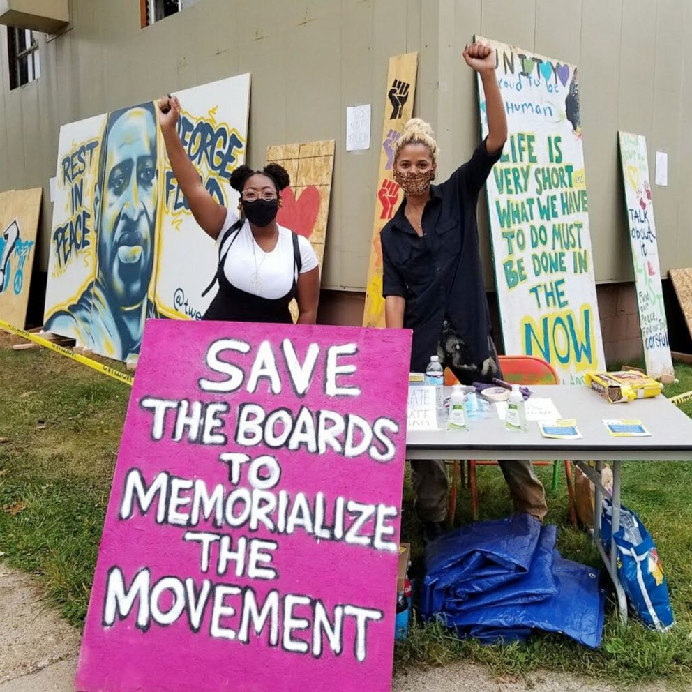 PHOTO: Leesa Kelly and Kenda-Zellner Smith pose with protest art they collected thought Save the Boards to Memorialize the Movement in Minneapolis. Protest art has been collected by Save the Boards to Memorialize the Movement.