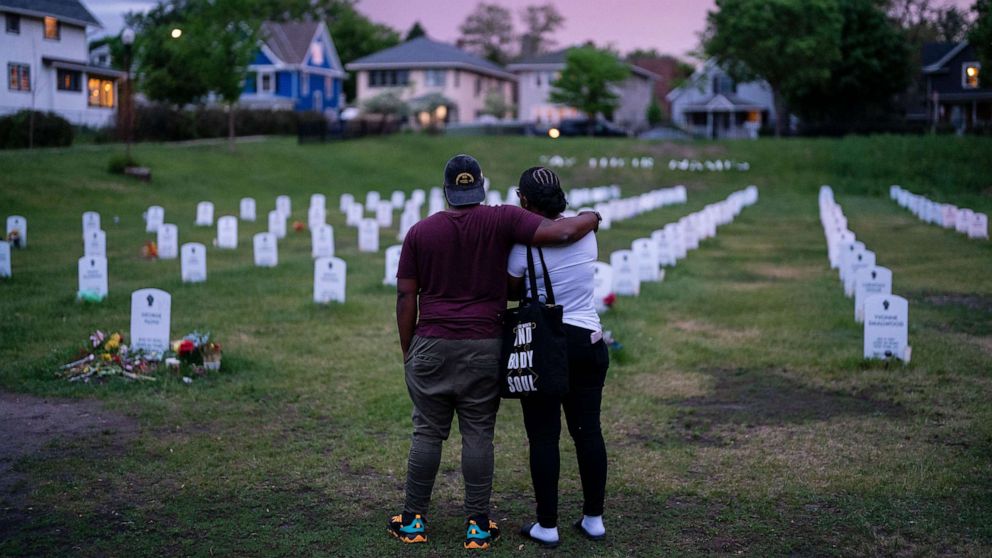 PHOTO: People visit and pay their respects at the Say Their Names Cemetery near the George Floyd Memorial Square on May 24, 2021 in Minneapolis, Minn.