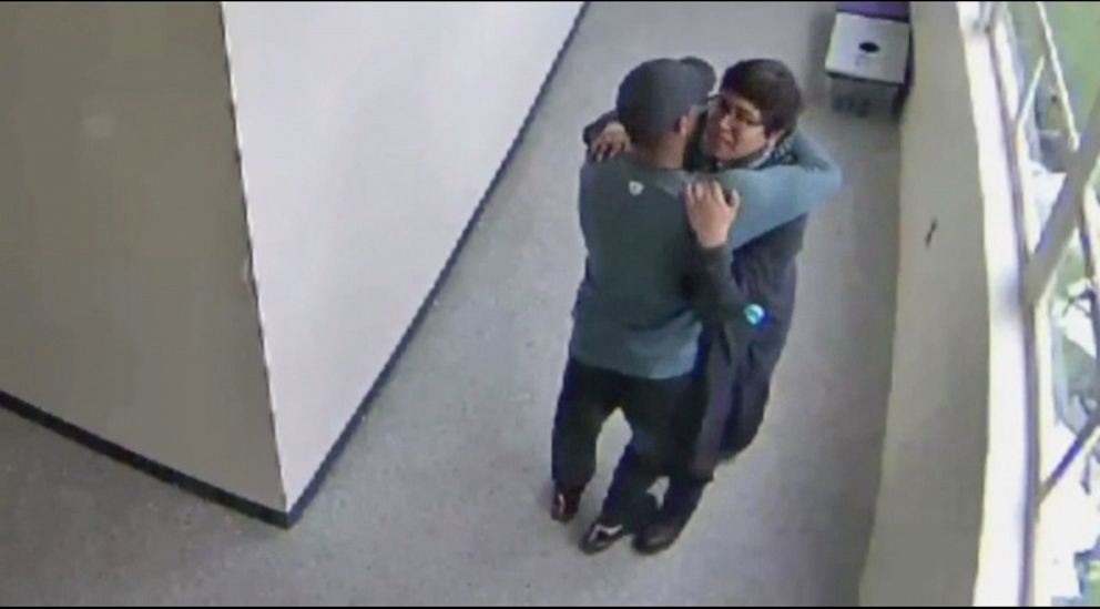 PHOTO: A still from security video shows Parkrose High School coach Keanon Lowe hugging a student who brought a shotgun to school.