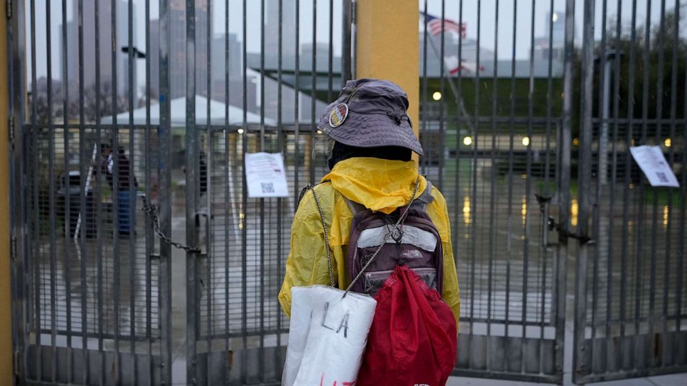 PHOTO: Los Angeles Unified School District (LAUSD) teacher Sarah Phillips stands under heavy rain outside the closed doors of the Edward R. Roybal Learning Center in Los Angeles, March 21, 2023.