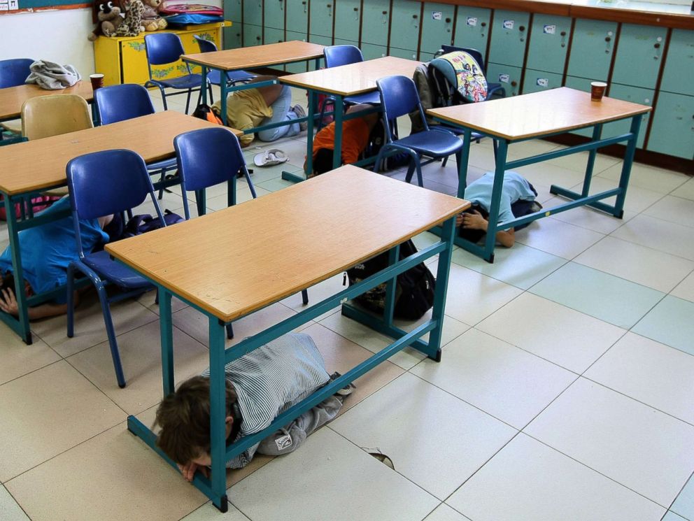 PHOTO: Students take cover under their desks in this undated image.