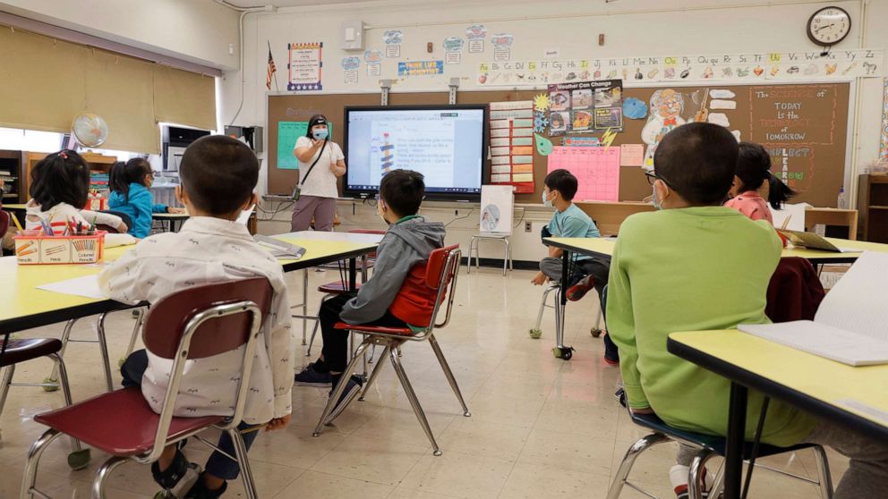 PHOTO: Melissa Wong, a teacher at Yung Wing School P.S. 124 gives a lesson to her masked students in their classroom, Sept. 27, 2021, in New York.