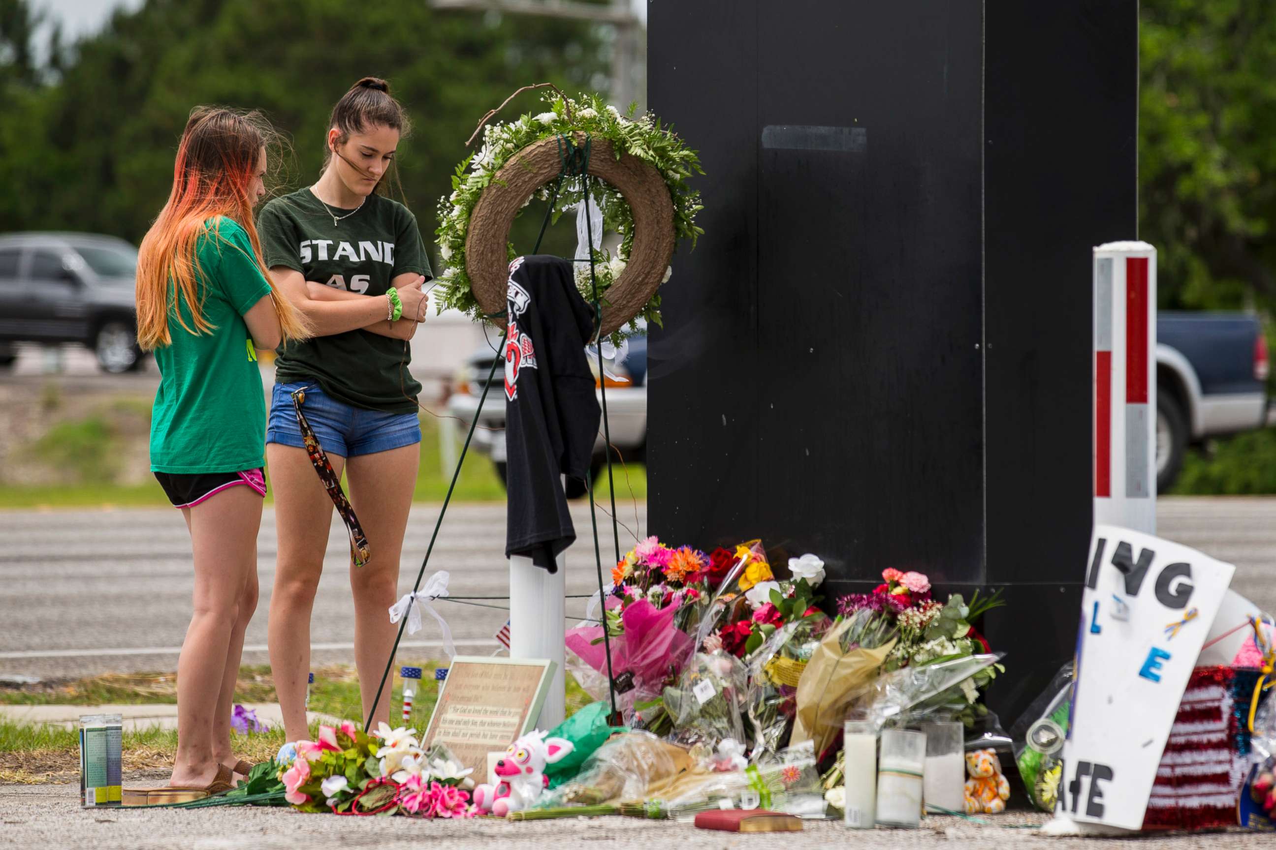 PHOTO: Kalysta Dodson, left, and Reagyn Murphy, sophomores at Santa Fe High School, look at a memorial for the victims of the Santa Fe High School shooting in Santa Fe, Texas.