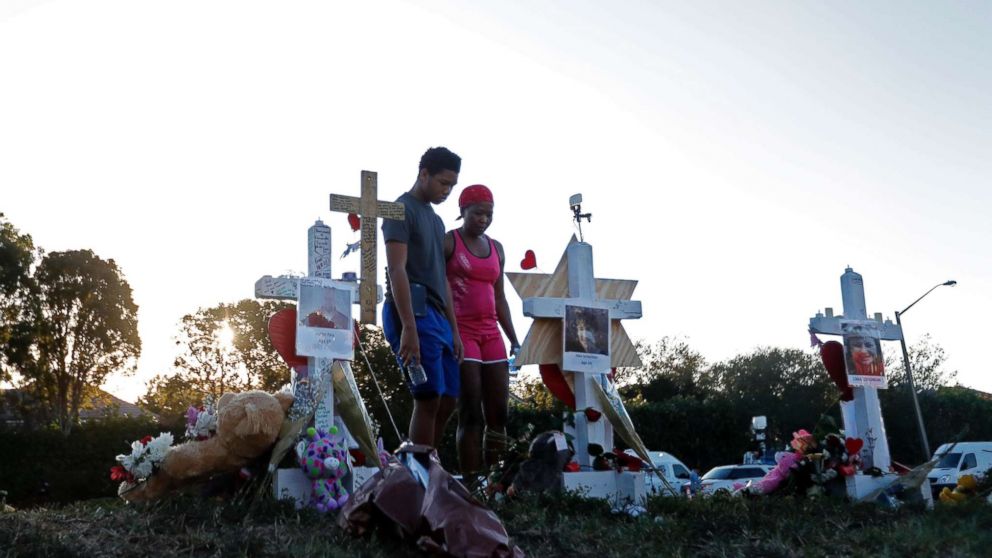 Denyse Christian, visits a makeshift memorial with her son Adin Christian, 16, a student at the school, outside the Marjory Stoneman Douglas High School.