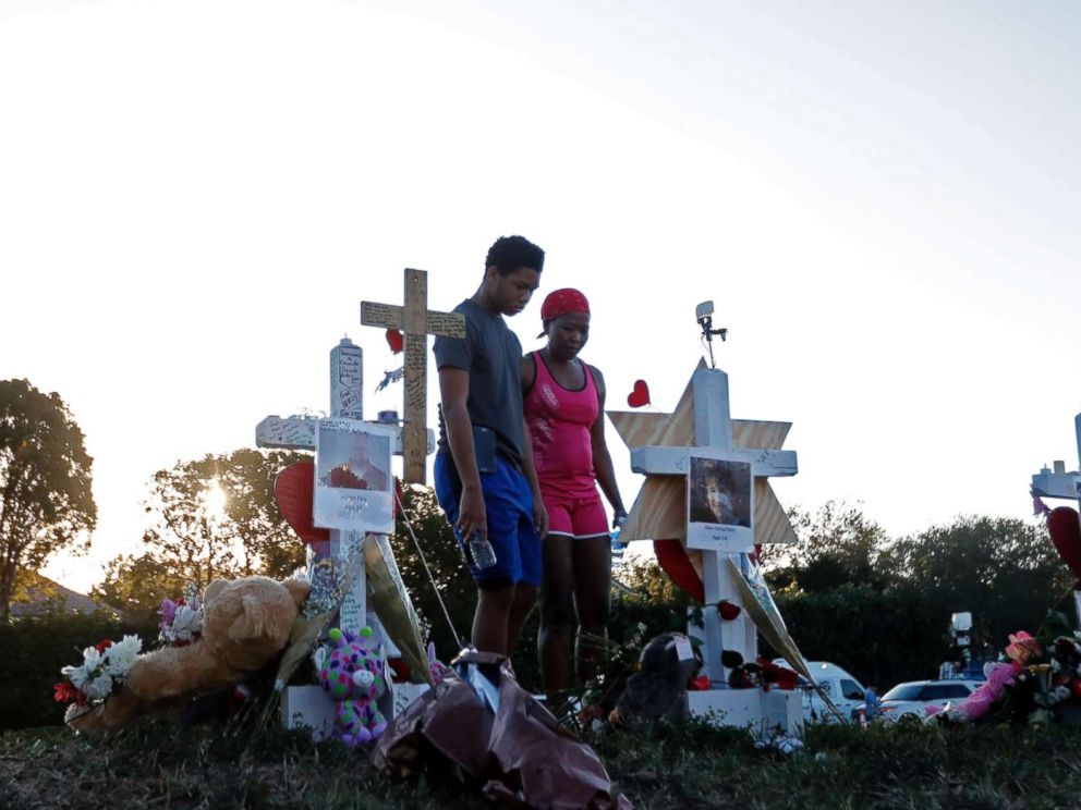 PHOTO: Denyse Christian, visits a makeshift memorial with her son Adin Christian, 16, a student at the school, outside the Marjory Stoneman Douglas High School.