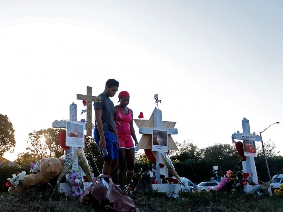 PHOTO: Denyse Christian, visits a makeshift memorial with her son Adin Christian, 16, a student at the school, outside the Marjory Stoneman Douglas High School.