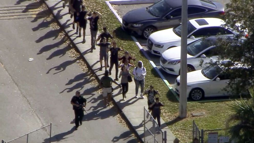 PHOTO: Students walk with an armed escort after after reports of a shooting at Stoneman Douglas High School in Parkland, Fla., Feb. 14, 2018.