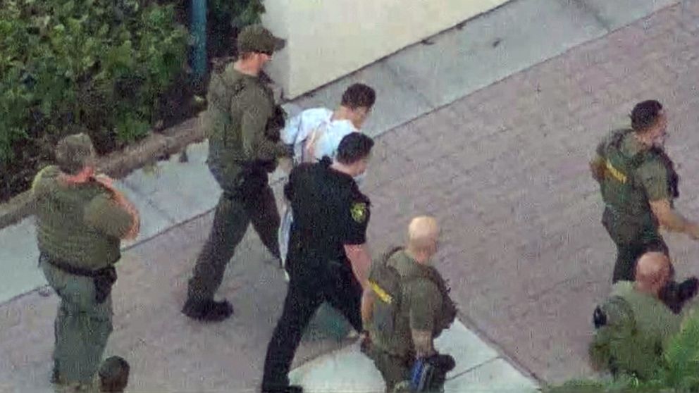 PHOTO: Nikolas Cruz, the suspect in a shooting at Marjory Stoneman Douglas High School in Parkland, Fla., is escorted into a police station, Feb. 14, 2018.