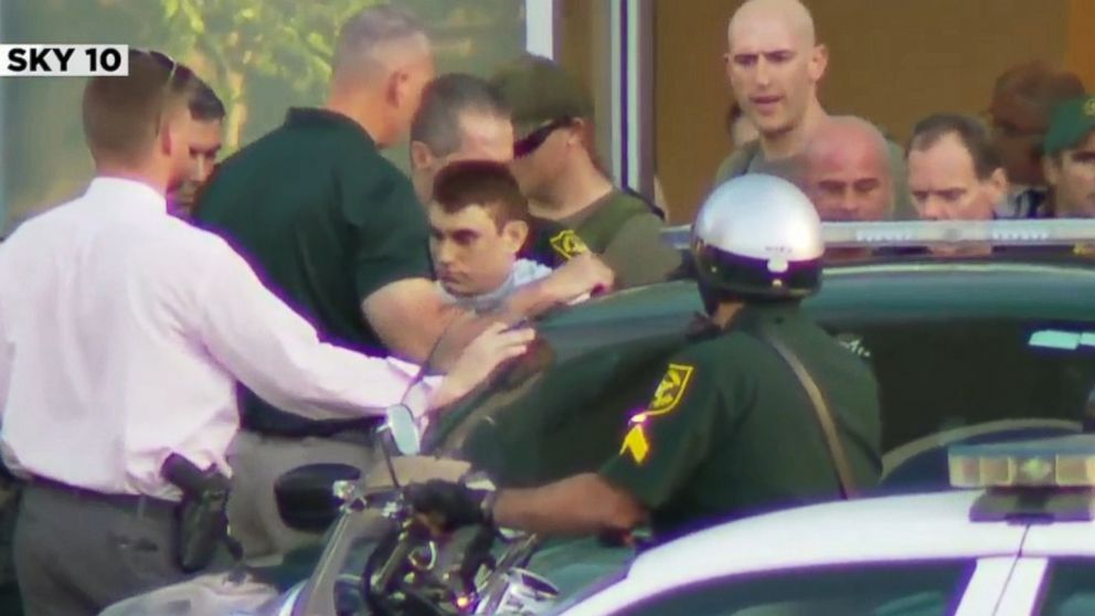 PHOTO: Nikolas Cruz, the suspect in a shooting at Marjory Stoneman Douglas High School in Parkland, Fla., is escorted out of a hospital and into a police car.