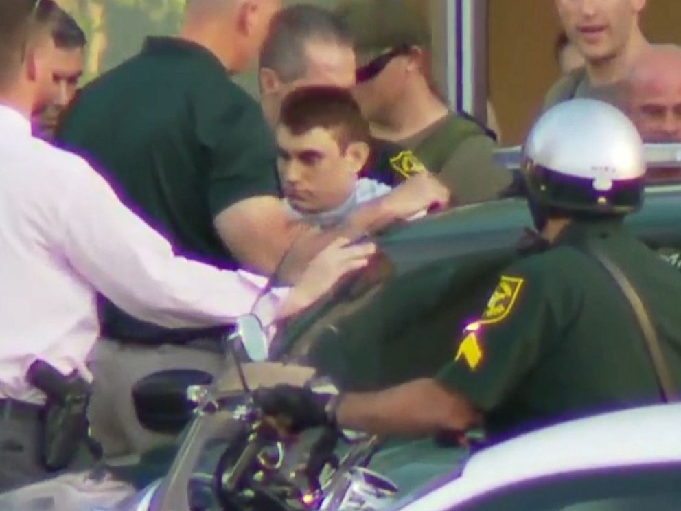 FOTO: Nikolas Cruz, o suspeito em um tiroteio no Marjory Stoneman Douglas High School em Parkland, na Flórida, é acompanhado de um hospital e em um carro da polícia.