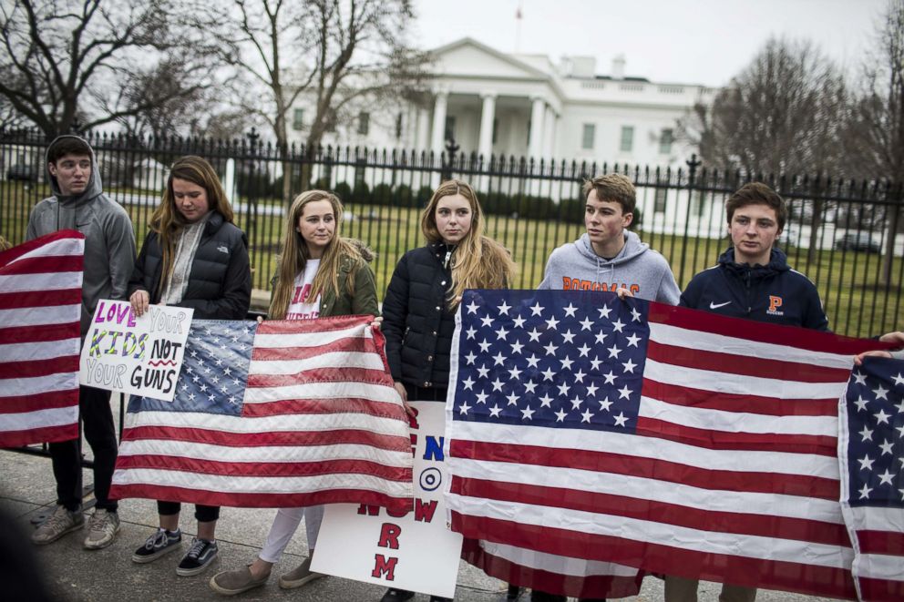 PHOTO: Demonstrators hold flags during a "lie-in" demonstration supporting gun control reform near the White House on Feb. 19, 2018, in Washington. 