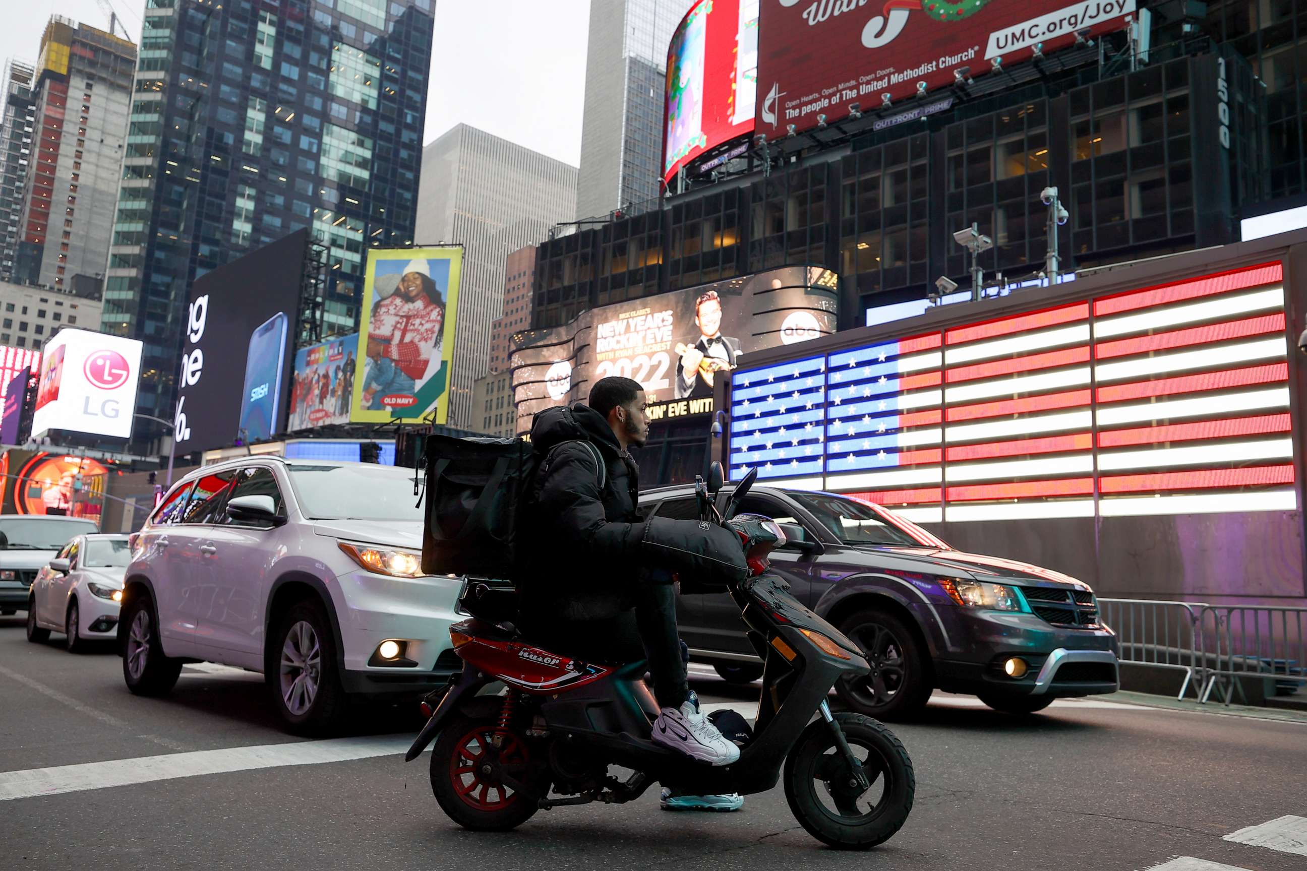 PHOTO: A food delivery guy with scooter is seen at the Times Square in New York City, December 29, 2021.