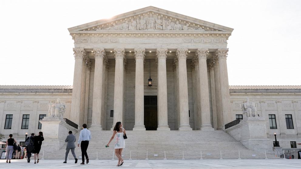 PHOTO: People walk in front of the Supreme Court building, as the court is set to issue the final rulings of its nine-month term, in Washington, June 30, 2026. 