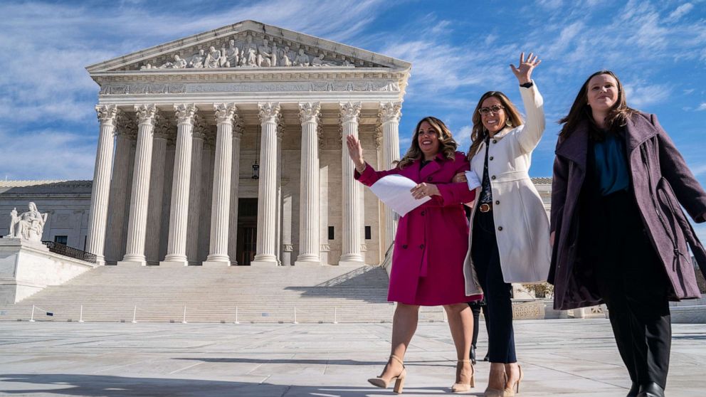 PHOTO: Lorie Smith, a Christian graphic artist and website designer in Colorado, in pink, prepares to speak to supporters outside the Supreme Court on Monday, Dec. 5, 2022 in Washington, DC.