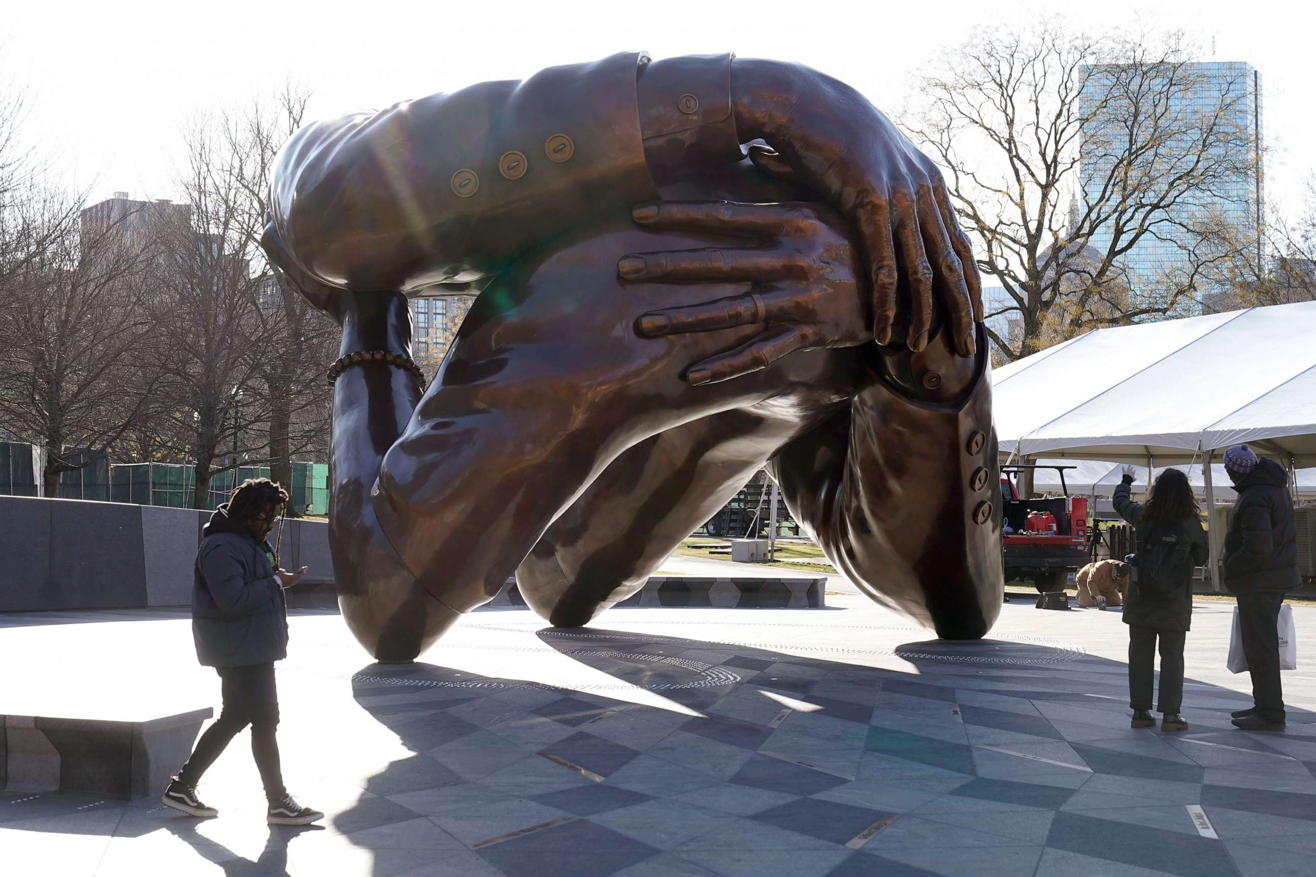 PHOTO: Passers-by walk near the 20-foot-high bronze sculpture "The Embrace," a memorial to Dr. Martin Luther King Jr. and Coretta Scott King, in the Boston Common, Jan. 10, 2023, in Boston.