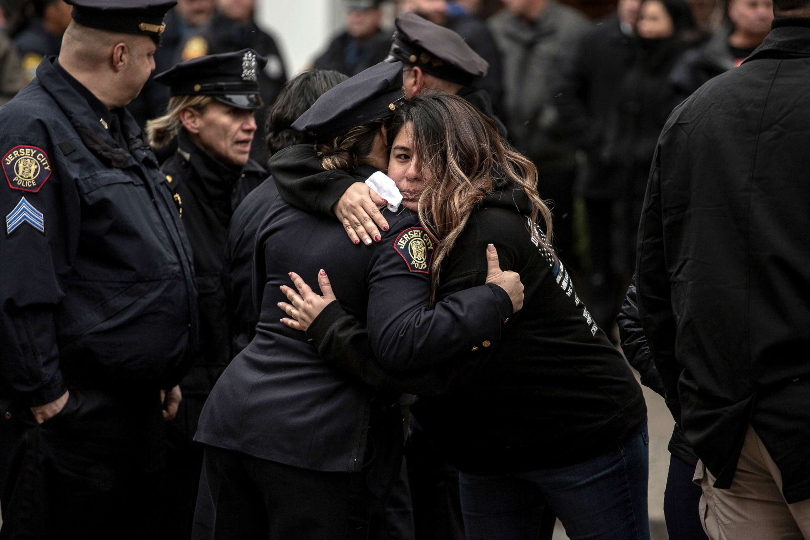 PHOTO: Mourners embrace during the wake for Detective Joseph Seals at McLaughlin Funeral Home in Jersey City, N.J., Dec. 16, 2019. 