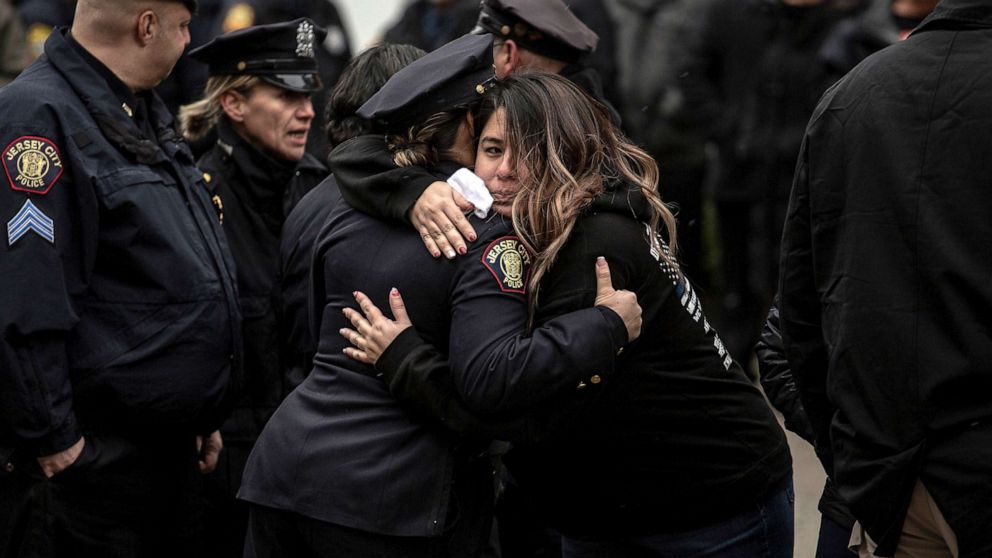 PHOTO: Mourners embrace during the wake for Detective Joseph Seals at McLaughlin Funeral Home in Jersey City, N.J., Dec. 16, 2019.