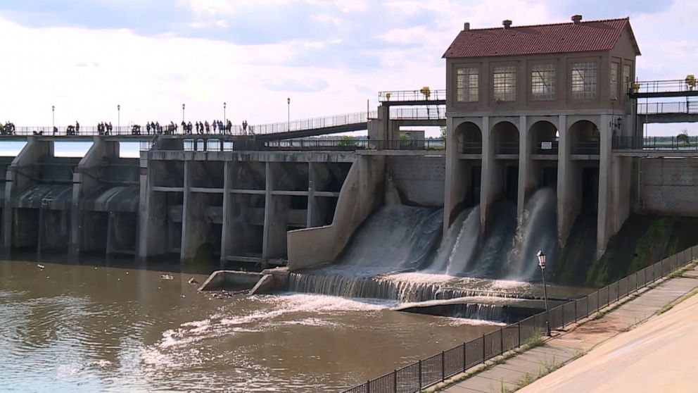 PHOTO: People watch as rescuers search for two boys swept away by strong currents on July 10, 2023, when the dam gates opened at Lake Overholser, in Oklahoma City.