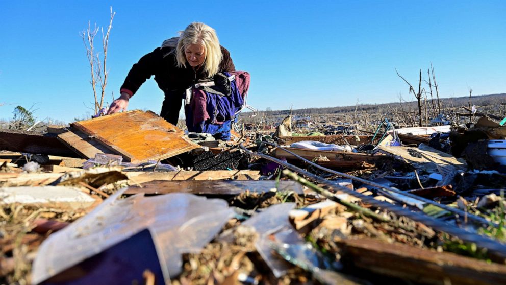 PHOTO: Laura Croft searches through debris near the location where her mother and aunt were found deceased after tornadoes ripped through several states, in downtown Dawson Springs, Ky., Dec. 13, 2021.