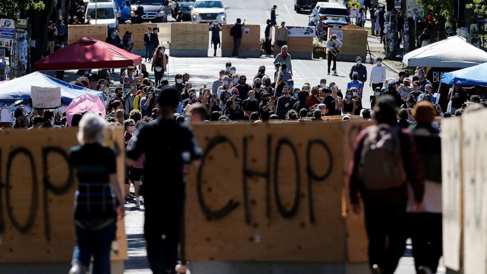 PHOTO: People walk between concrete barriers newly installed by the city as protesters demonstrate against racial inequality and occupy space at the CHOP area near the Seattle Police Department's East Precinct in Seattle, June 16, 2020.