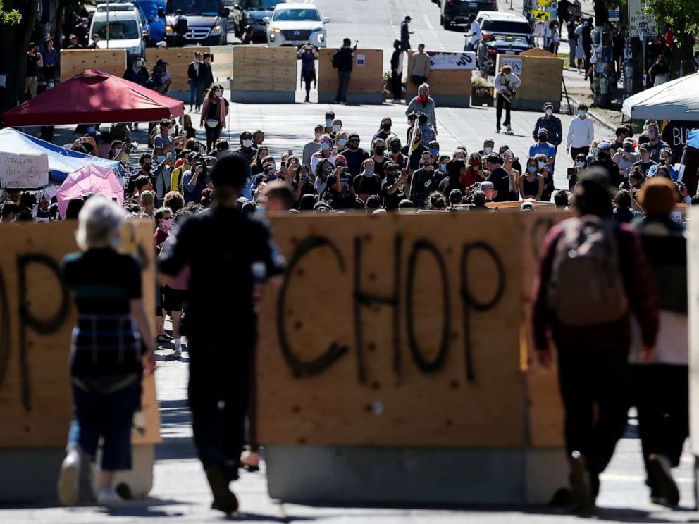 PHOTO: People walk between concrete barriers newly installed by the city as protesters demonstrate against racial inequality and occupy space at the CHOP area near the Seattle Police Department's East Precinct in Seattle, June 16, 2020.