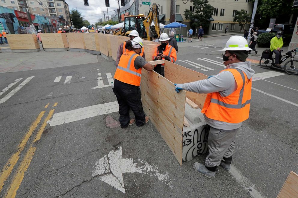 PHOTO: City workers install new cement and wood barricades, June 16, 2020, inside what has been named the Capitol Hill Occupied Protest zone in Seattle. 
