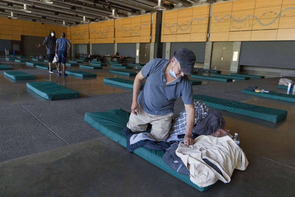 PHOTO: Roberto Cedomio prepares his bed at a cooling shelter run by the Salvation Army at the Seattle Center during a heat wave hitting the Pacific Northwest, June 27, 2021, in Seattle.
