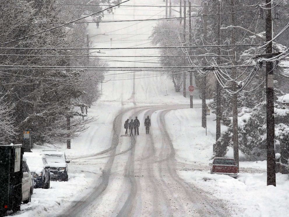 PHOTO: Pedestrians cross a deserted street as heavy snow falls, Feb. 11, 2019, in Seattle.