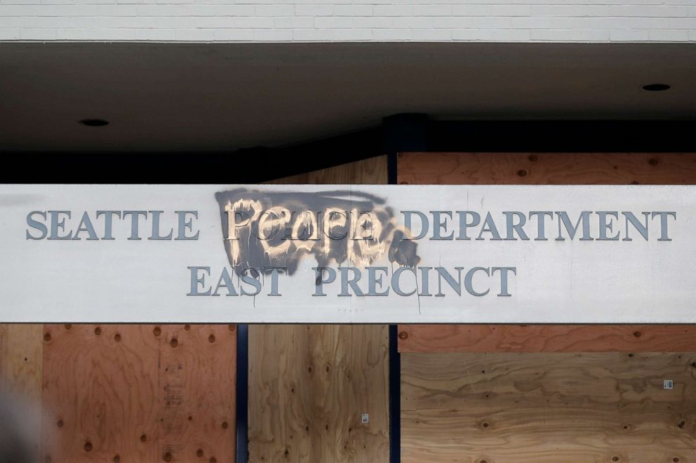 PHOTO: A modified sign for the Seattle Police Dept. East Precinct building, which has been boarded up and abandoned except for a few officers inside, is shown, June 11, 2020 in Seattle.