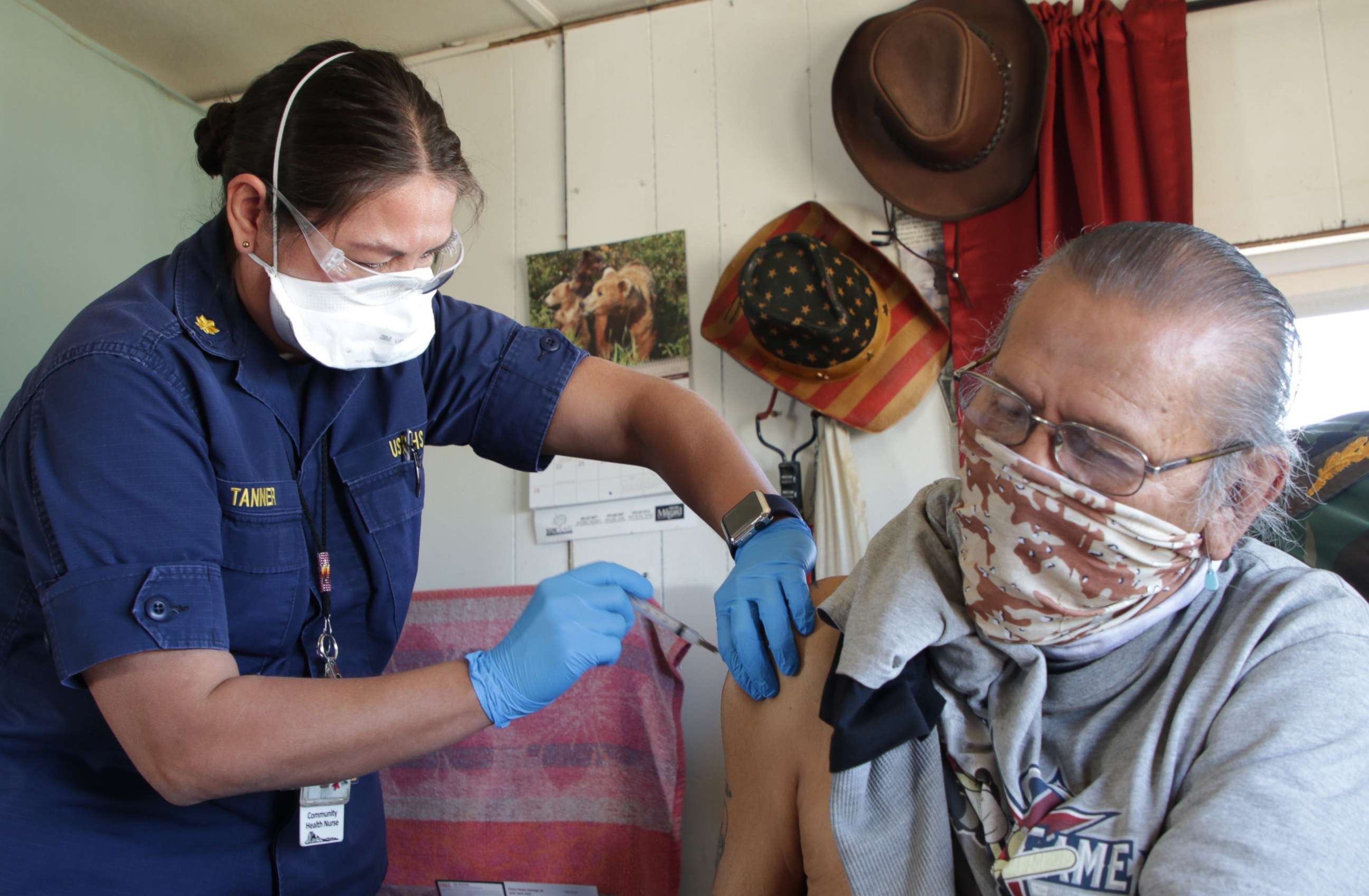 PHOTO: Robbin Tanner, a public health nurse with Northern Navajo Medical Center, administers the first dose of the Moderna COVID-19 vaccine to David Mays at his home in Fruitland, Farmington, N.M., Feb. 24. 2021.