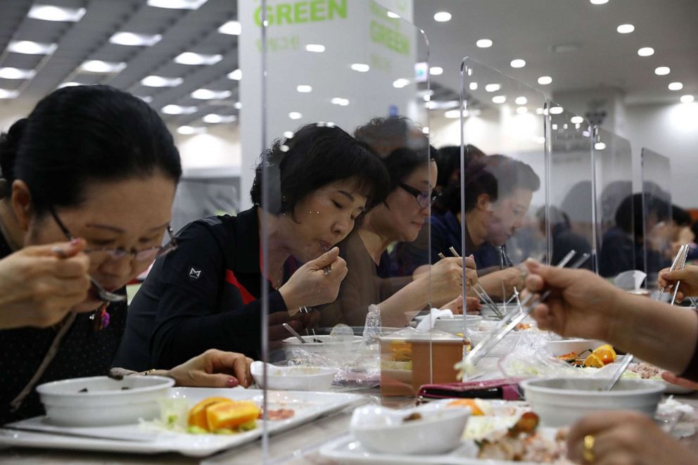 PHOTO: People eat lunch behind protective plastic barriers on the table between diners as South Koreans take measures to protect themselves against the spread of coronavirus (COVID-19) in a cafeteria in Seoul, May 20, 2020.