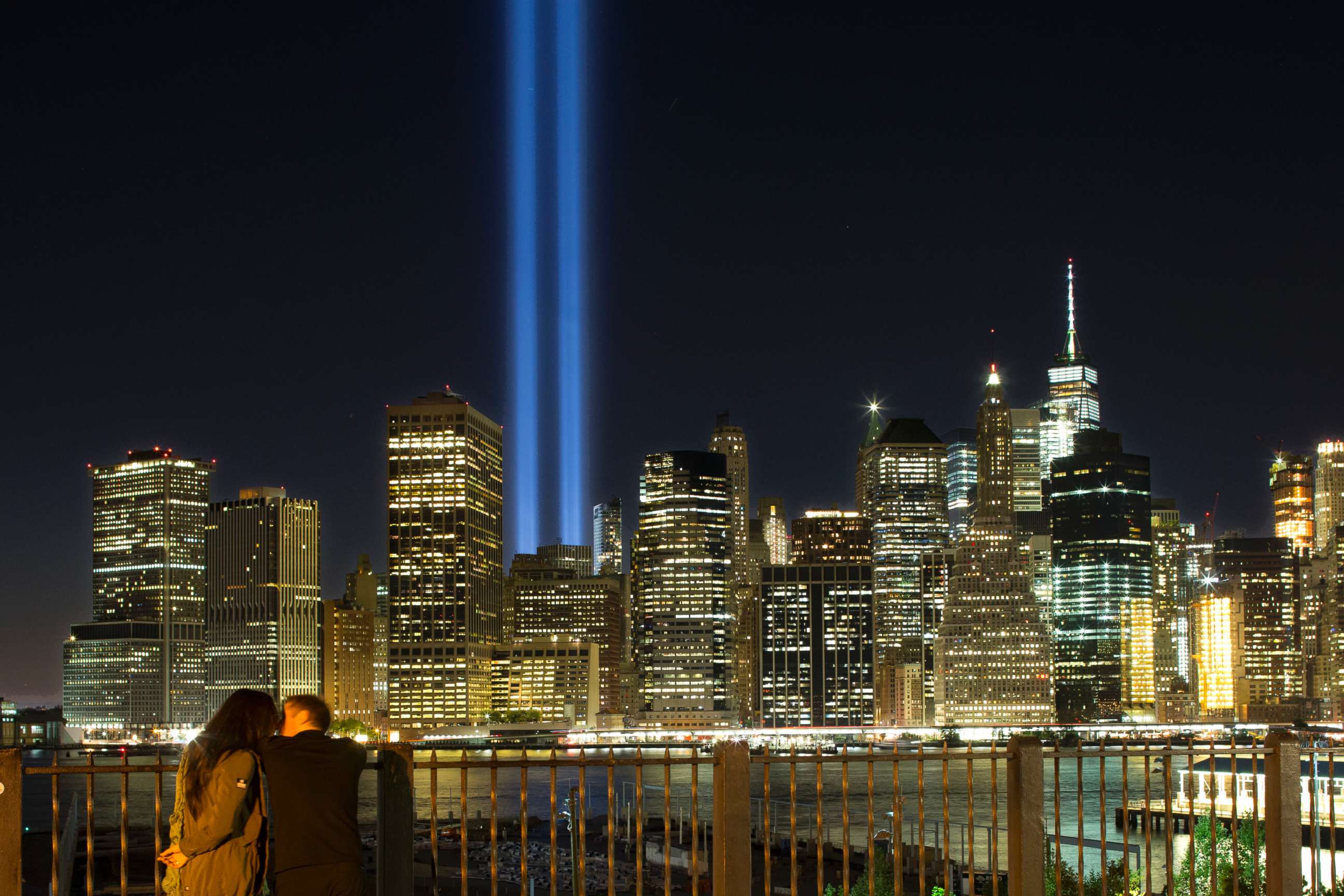 PHOTO: A couple embraces on the Brooklyn Promenade as the Tribute in Light rises above the lower Manhattan skyline, Sept. 10, 2017, in New York. 