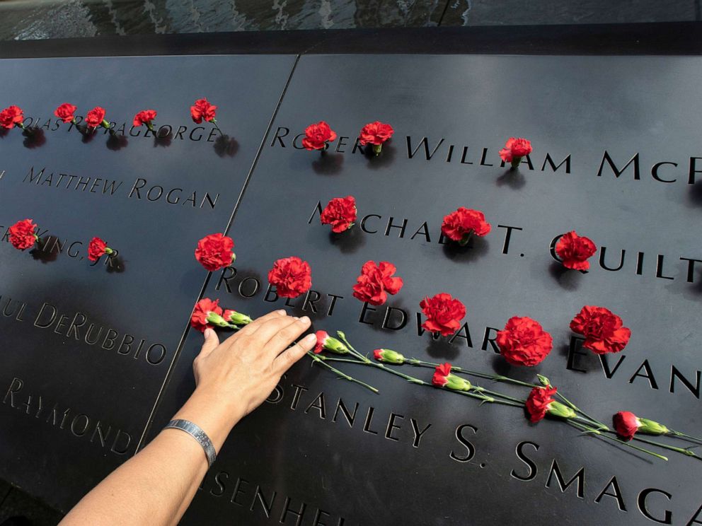 PHOTO: Norma Molina, of San Antonio, Texas, leaves flowers by the names of firefighters from Engine 33 at the September 11 Memorial, Sept. 9, 2019, in New York.