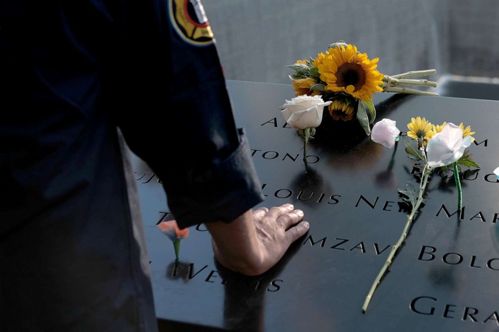 PHOTO: People gather at one of the pools at the National September 11 Memorial following a morning commemoration ceremony for the victims of the terrorist attacks, Sept. 11, 2019, in New York City.