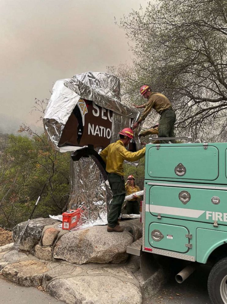 PHOTO: In this picture released by the National Park Service on Sept. 16, 2021, firefighters wrap the historic Sequoia National Park entrance sign with fire-proof blankets in Sequoia National Park, Calif.