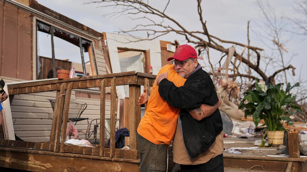 PHOTO: Tim Scott, right, gets a hug from friend Jorden Harris outside Scott's home he was inside when it was destroyed during a severe storm the evening before, Mar. 15, 2025, in Wayne County, Mo.
