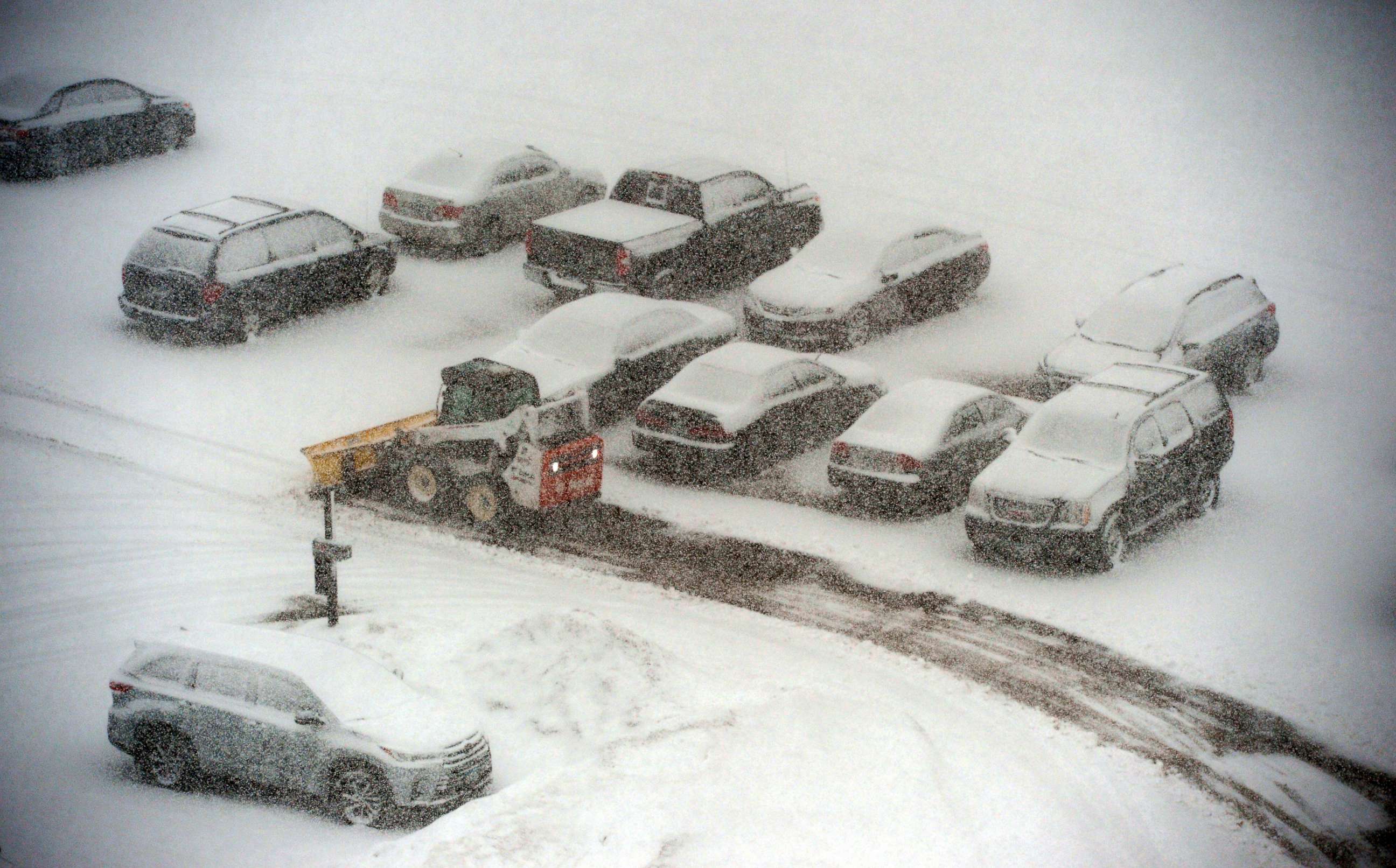 PHOTO: A snowplow makes its way past snow-covered cars in a parking lot in St. Paul, Minn., March 5, 2018. 