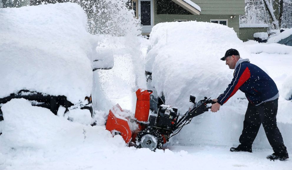 PHOTO: John Visco clears snow from around the cars in his driveway in Derry, N.H., March 8, 2018. 