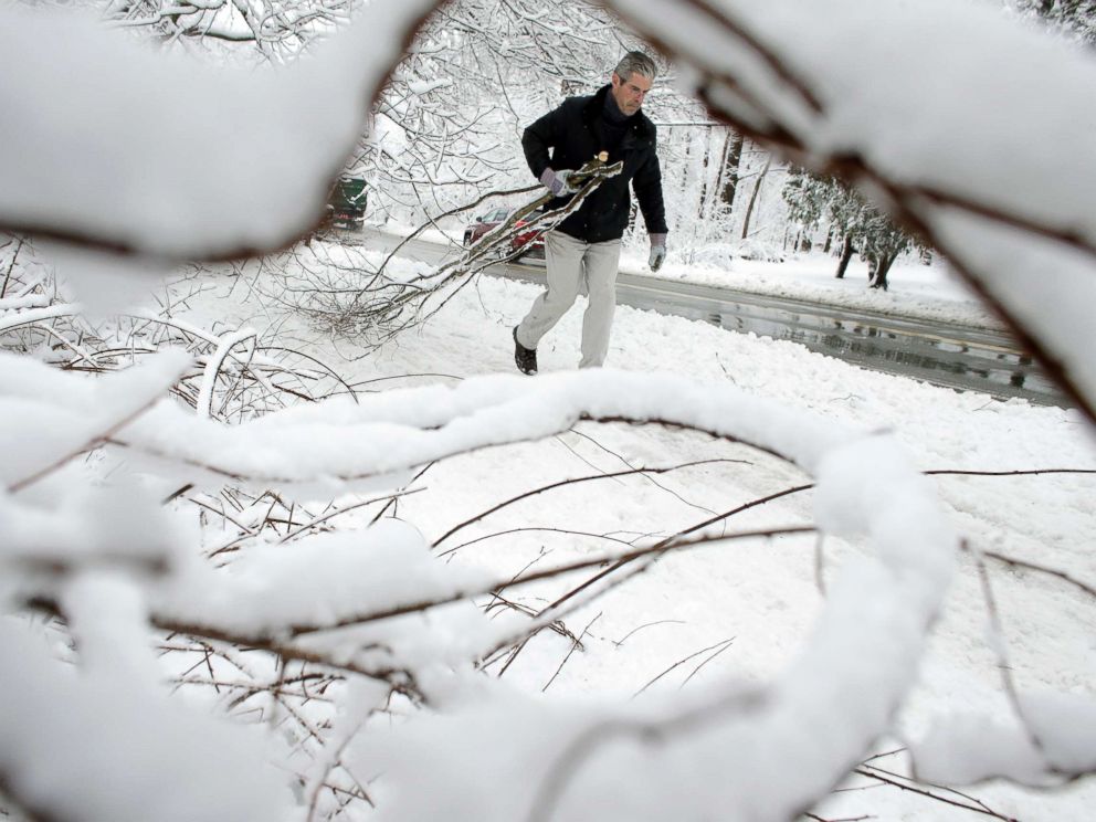 PHOTO: Kevin Crowley, of Weyland, Mass., works to remove damaged tree branches from a driveway, March 8, 2018, in Sherborn, Mass.